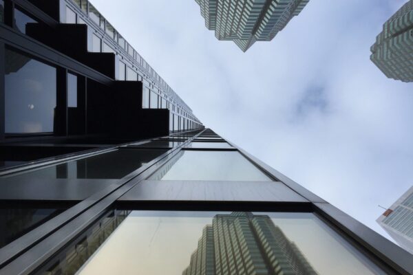 A low angle view of skyscrapers against a cloudy sky.