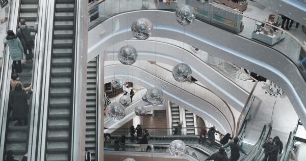 A group of people going up the escalator at an indoor mall.